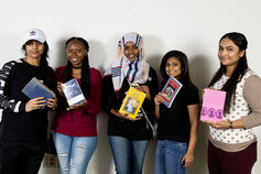 A group of students, each holding a book.